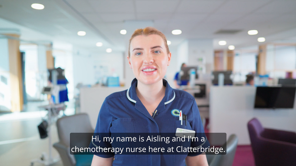 Screenshot from the video showing a female nurse in a blue uniform - she is smiling and is in one of the chemotherapy treatment units