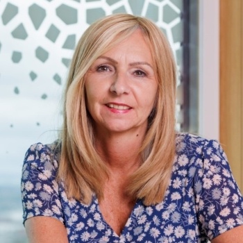 Jayne has long blonde hair with a central parting