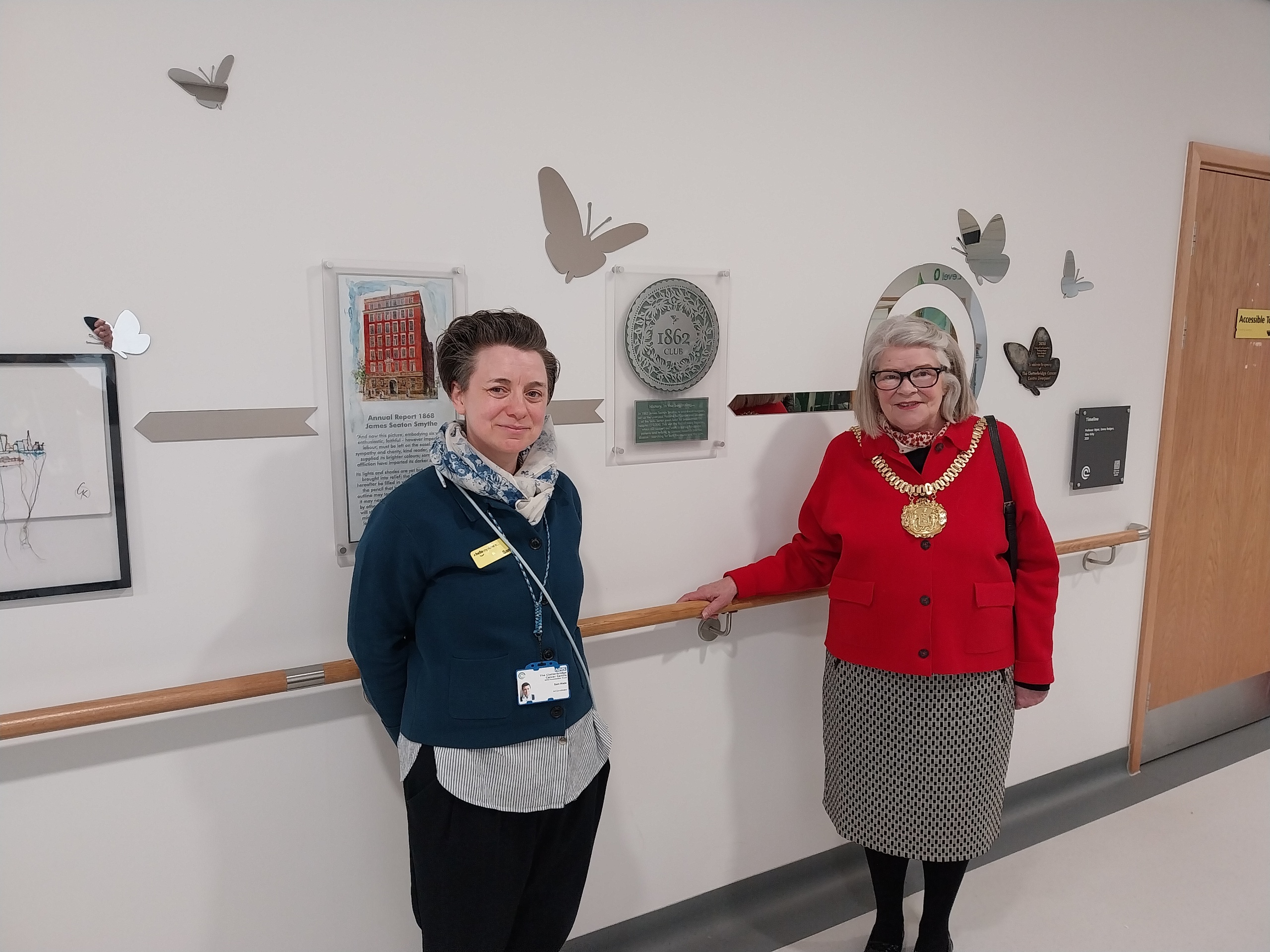 Lord Mayor and a hospital staff member standing by artwork showing the hospital's history