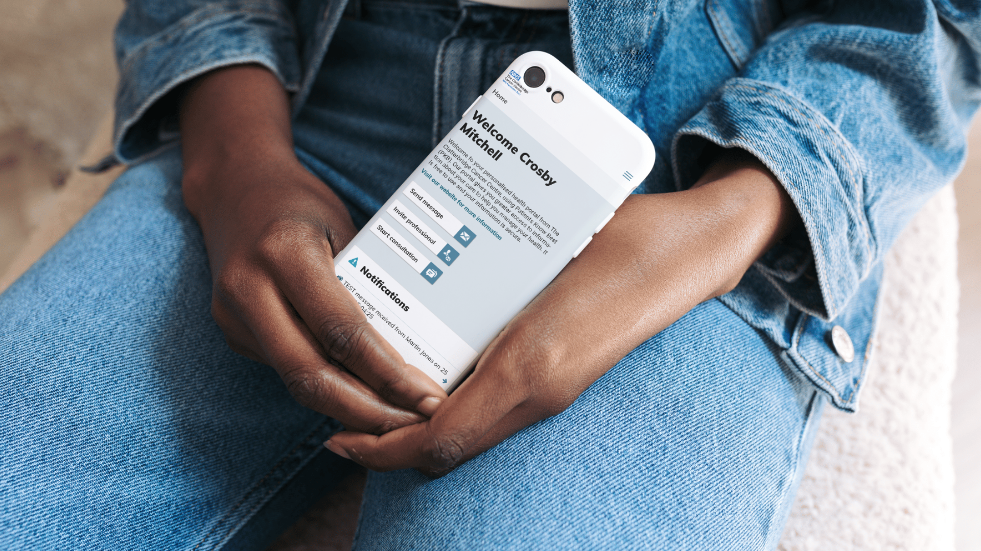 Man holding mobile phone showing PKB homepage